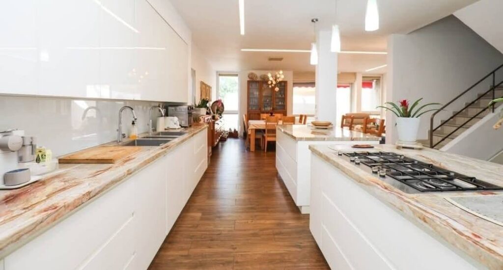 מטבח מודרני פתוח עם אי גדול ורצפת עץ ברמת פולג נתניה