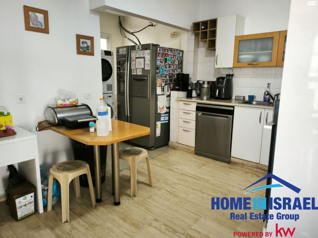 Kitchen and breakfast corner with white cabinets in Ya'akov Dori apartment