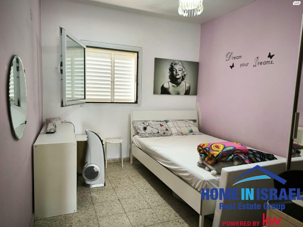 Bright bedroom with pink wall and large window in Netanya penthouse