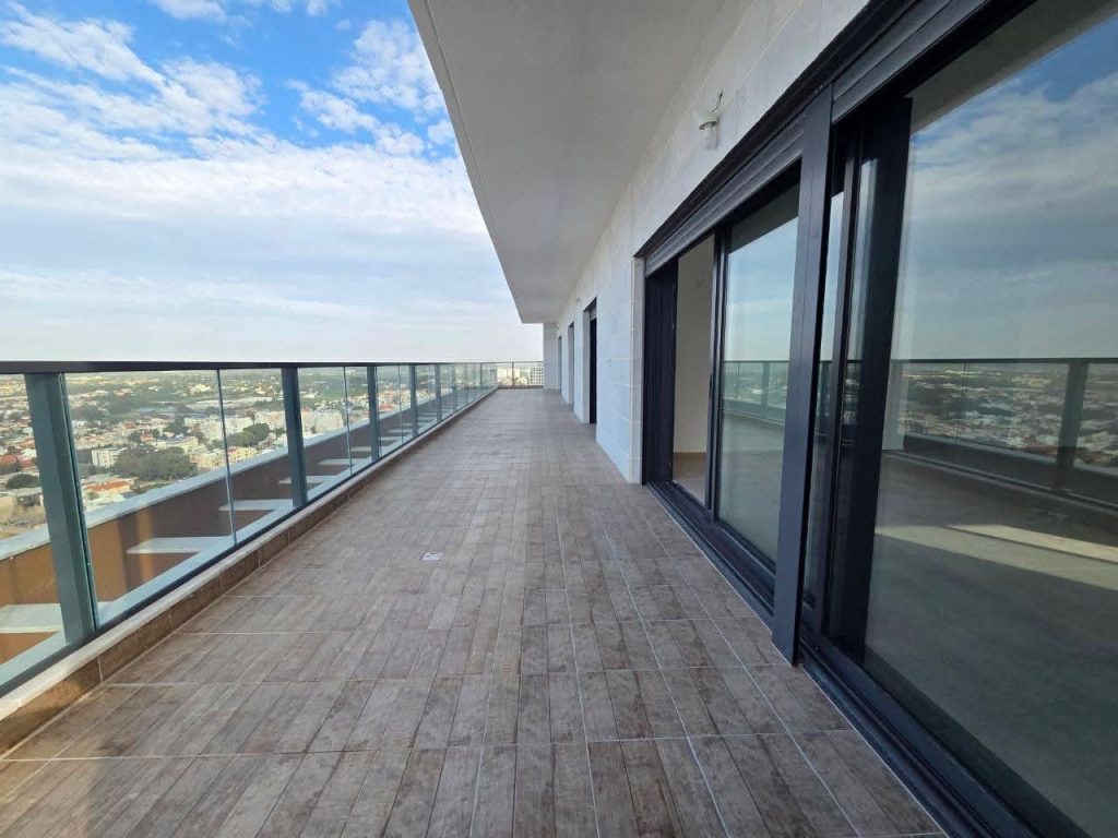 Large 70 SQM private terrace on the 25th floor of Rotem Shani Netanya with glass railings and sea view.